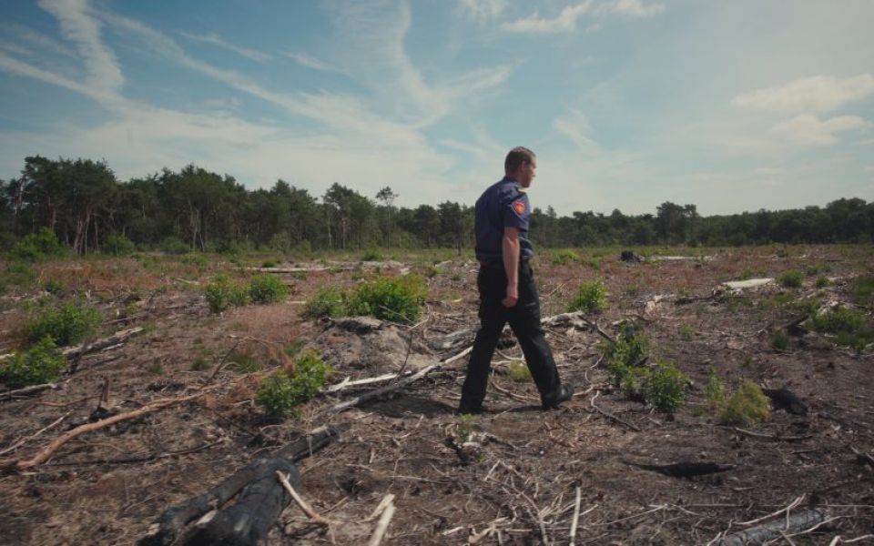 brandweerman op afgebrand natuurgebied