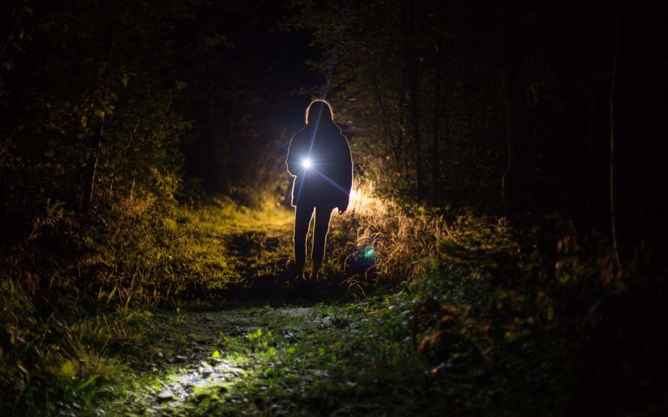 vrouw met zaklamp in donker