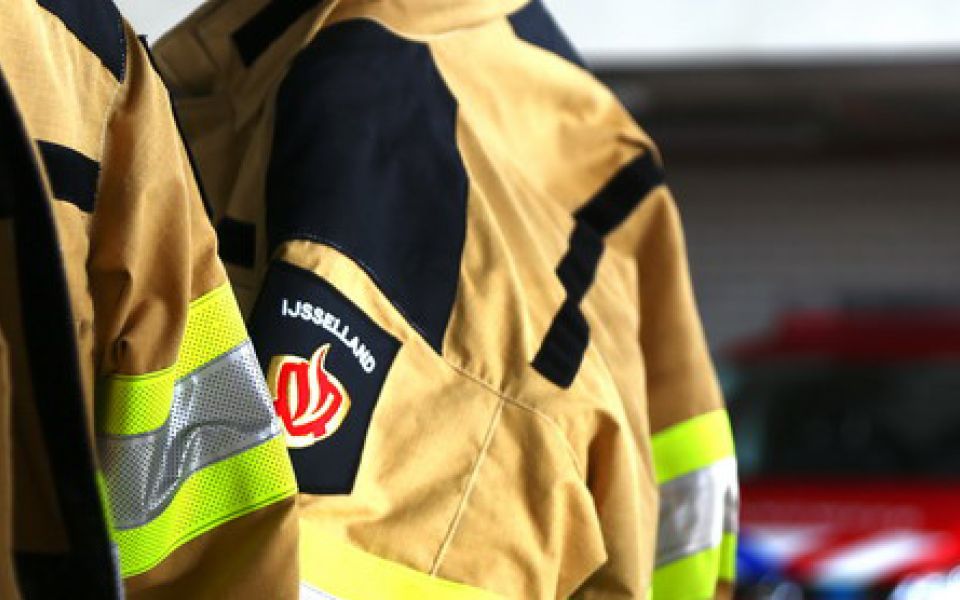 twee brandweerblusjassen met brandweerauto sfeerfoto