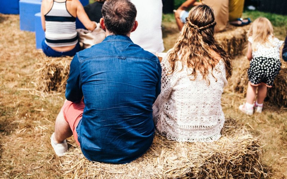 de achterkant van man en vrouw zittend op hooibaal